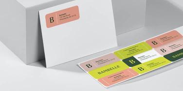 White envelope with pink mailing label and sticker sheet of 9 personalized address labels in various designs