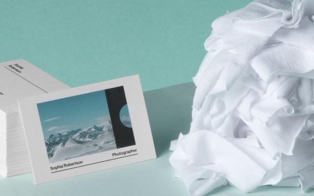 Photographer Cotton Business Card and pile of recycled Business Cards next to white t-shirt scraps on light green background