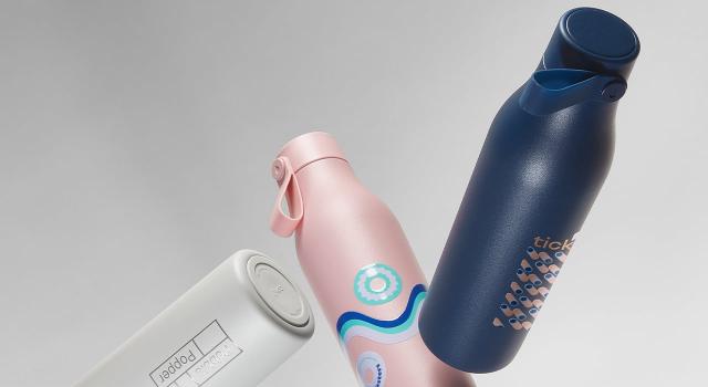 Three custom bottles in grey, pink and blue with colorful designs