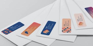 6 white envelopes with custom return address labels in various designs