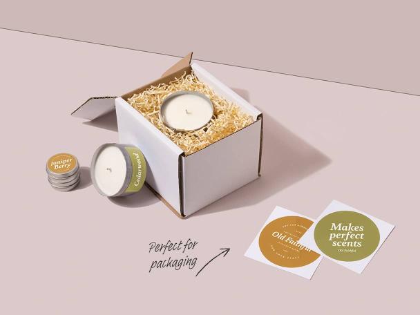 Candle in its packaging, cedarwood candle, balm tin with small round sticker and two big round stickers with brand messaging