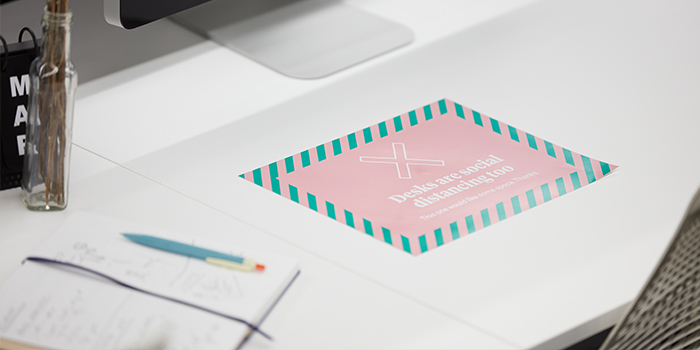 Pink and green sticker on a desk to ensure effective social distancing in the office