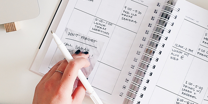 Writing with a pen in a busy daily planner