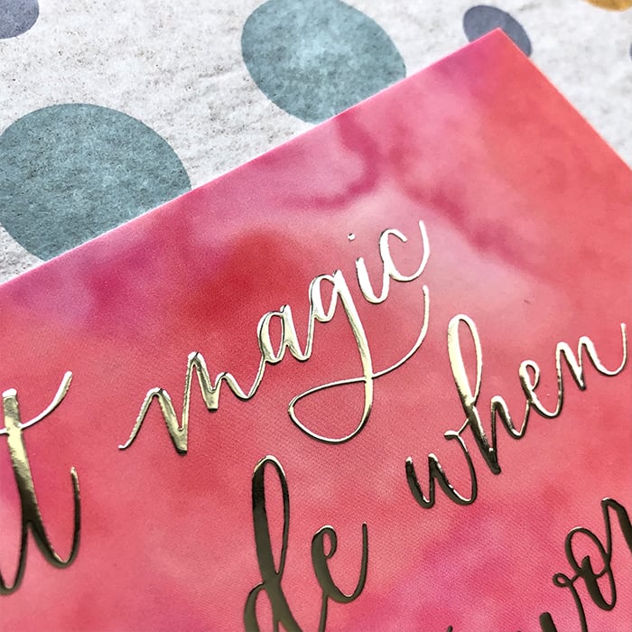Detail of a silver foil lettering by Bright Spot Papier on a pink postcard