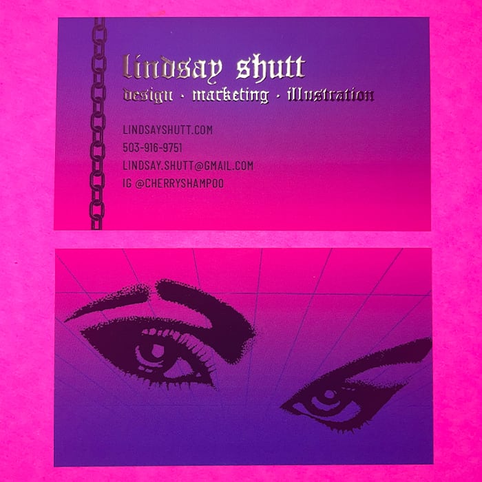 Purple and fuchsia business card with gothic text in silver foil. There is a pair of eyes on the back of this card designed by Lindsay Shutt