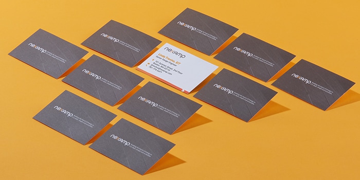 Nexamp cotton business cards with a grey back and a white front on a yellow background