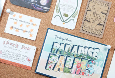 Mosaic of print products on a cork board including a Paradise Palms postcard and various business cards