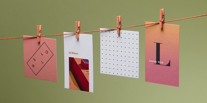 Recycled cotton business cards in various sizes and designs on a laundry line