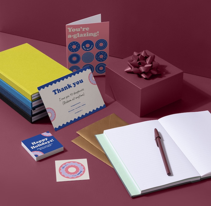 Open notebook, wrapped present, thank you card, greeting card, square business cards and round sticker