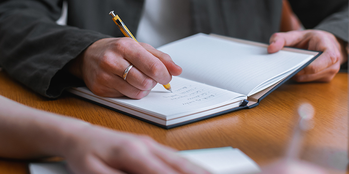 Hand writing in a MOO Hardcover Notebook