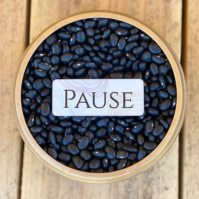 Pause Anywhere card with rounded corners on a bowl of black pebbles