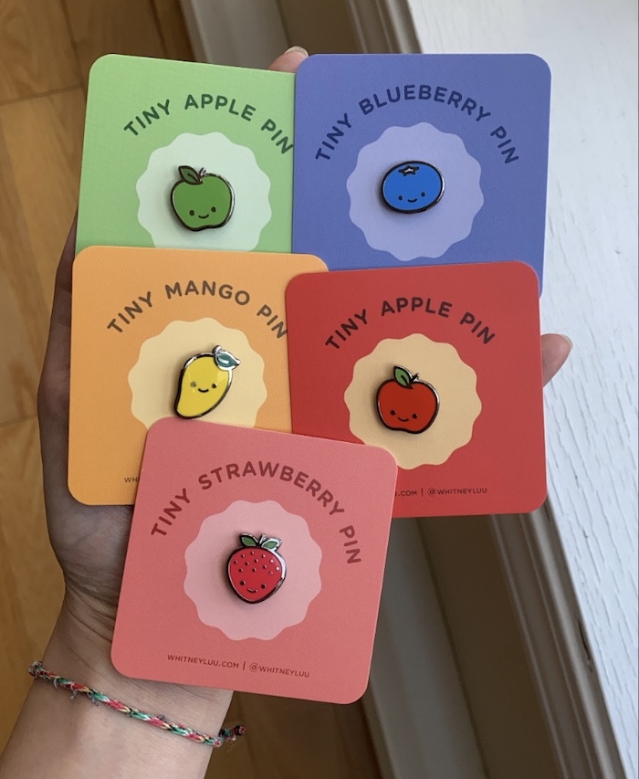 Five fruit pins on colorful backing cards with rounded corners by Whitney Luu