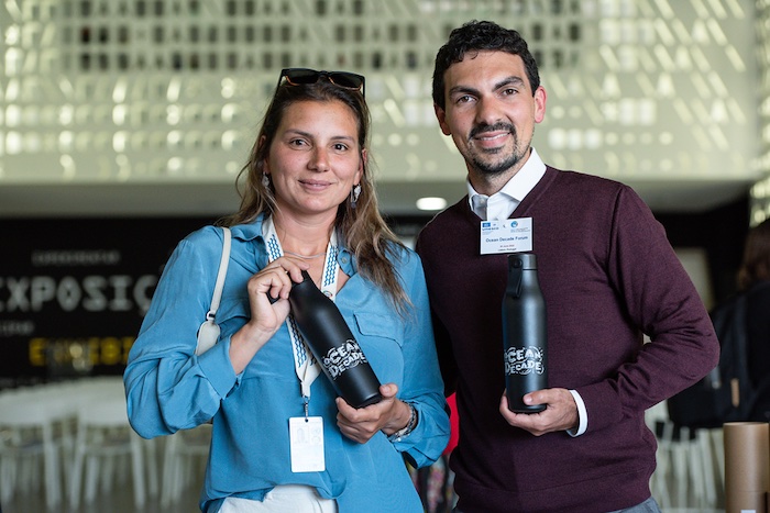 Maya Gabeira y Vinicius Lindoso con botellas de agua personalizadas de MOO en la Década del Océano