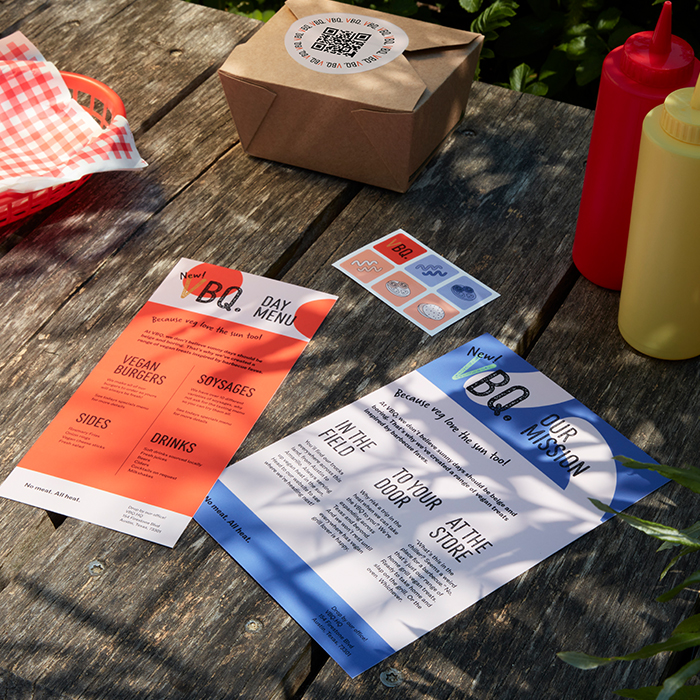 A BBQ menu on a picnic table with a good box and sauces