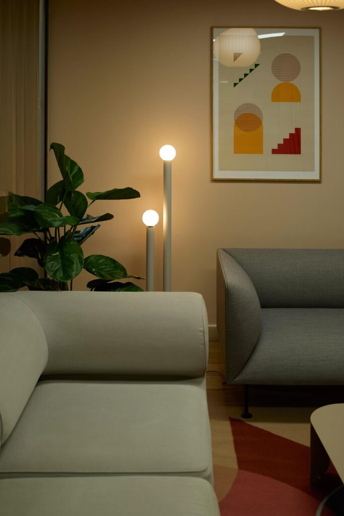 Dimmed lights in meeting room with comfortable couches and nice prints.