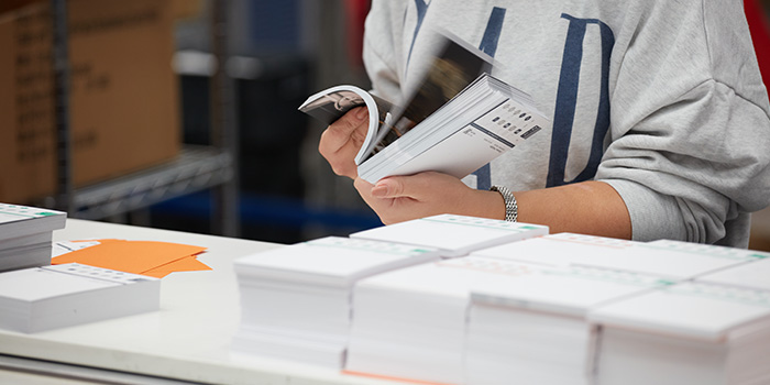 A factory order of bulk printing flyer being checked by an employee