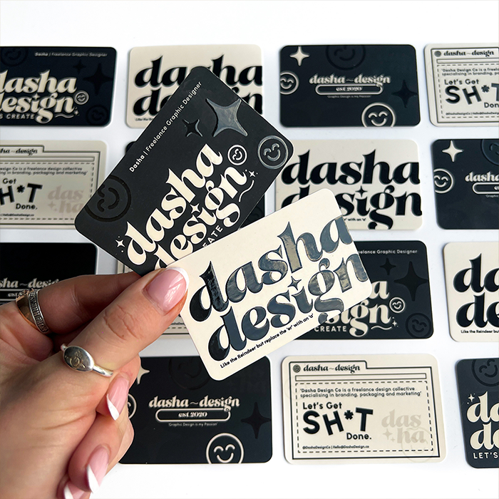 Dasha's hand showcasing her Spot Gloss Business Cards.