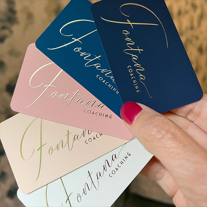 Business Cards with Gold Foil logo being held by person.
