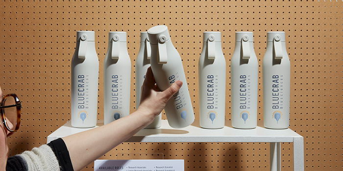 Branded MOO Water bottles being used as gifted merchandise at a trade show