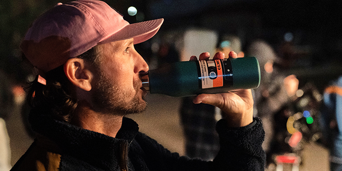 Olmo Cast memeber sipping on MOO Water Bottle on set.