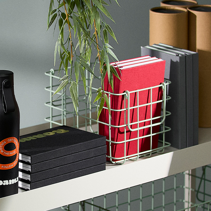 Stacks of Notebooks on shelving unit.