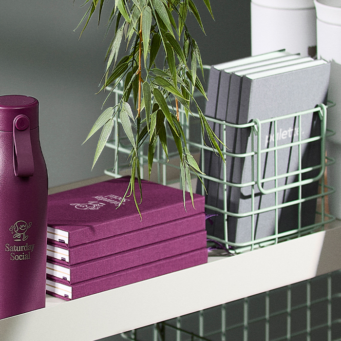 Pile of Notebooks and Drinkware on shelves.