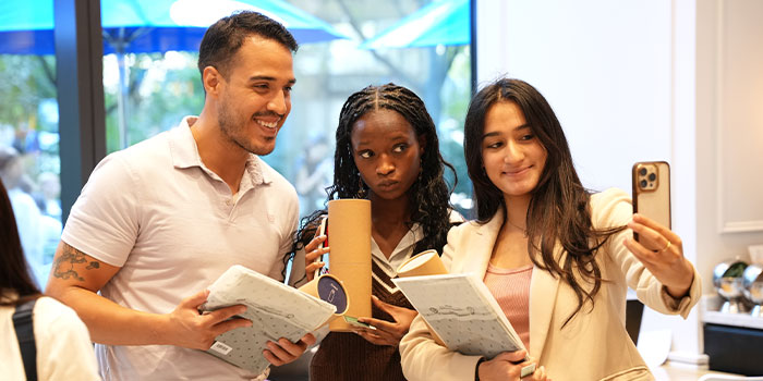 Three people holding MOO products.