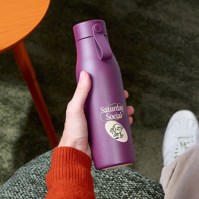 MOO Water Bottle held by person.