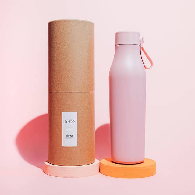 Botella de agua rosa con asa de transporte y su empaque de tubo de cartón.