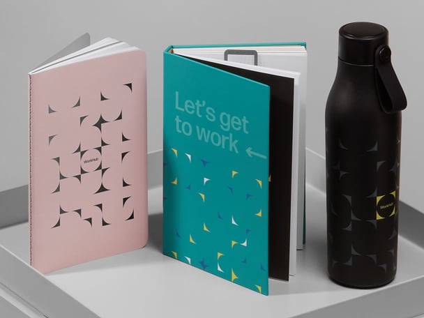 Dos agendas personalizadas en diferentes colores y una botella de agua MOO personalizada 