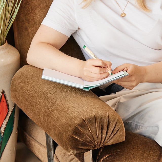 Femme assise et écrivant sur un Agenda Intemporel