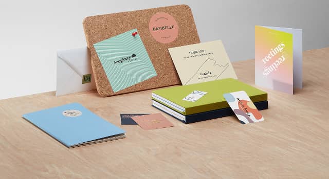 Gama de productos MOO que incluye 3 pegatinas, 1 volante, 1 postal, 1 tarjeta de felicitación, 2 cuadernos, 4 tarjetas de visita, 1 cuaderno y 1 sobre