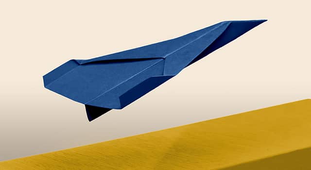 Avion en papier bleu sur fond beige
