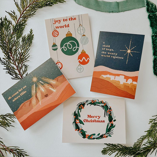 Tres tarjetas de felicitación de temporada con un sobre rodeado de decoraciones festivas