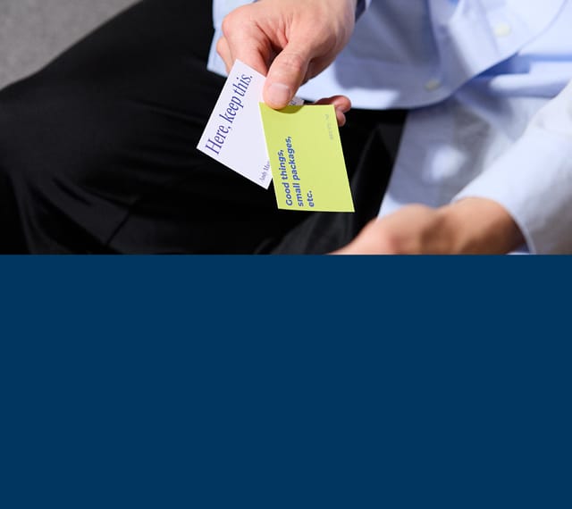 Two business cards being held