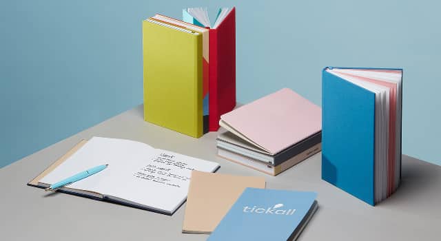 Cuadernos de tapa dura coloridos, diarios de tapa blanda, cuadernos personalizados y cuaderno abierto con notas escritas a mano y bolígrafo