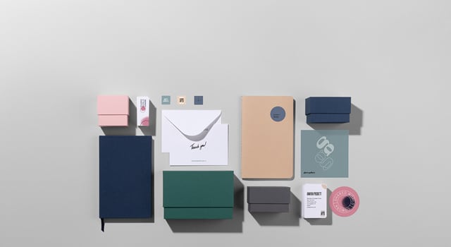 Flat lay picture of notebooks, display boxes for stationery, notebooks, business cards and stickers in various colours and designs