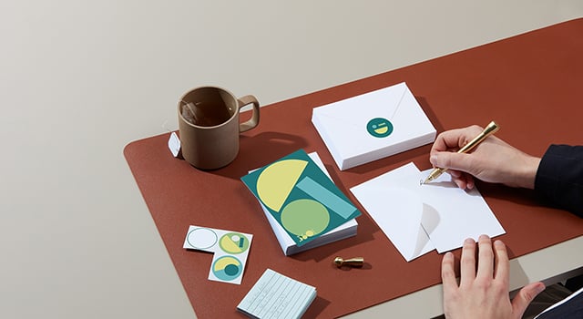 Escritura a mano en tarjetas postales con sobres sobre un escritorio