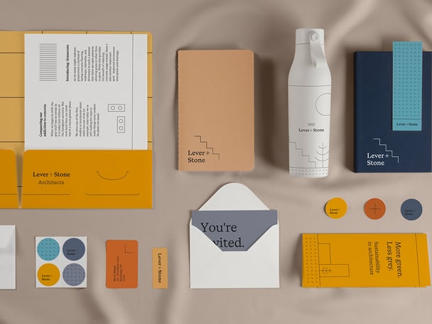 Custom water bottle with logo next to its tube packaging and 3 sizes of business cards in a red key dish on a red table