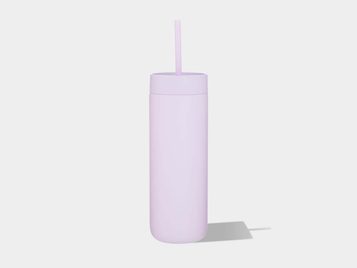A light purple, cylindrical insulated tumbler with a matching lid and straw stands upright on a light gray background, casting a shadow to its right.