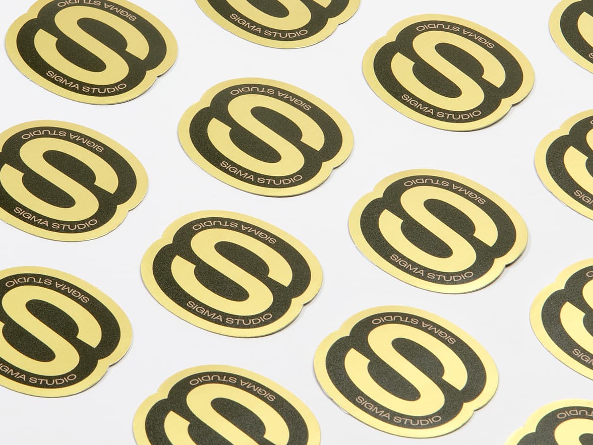 A collection of customized gold metallic stickers in the shape of a bold S.