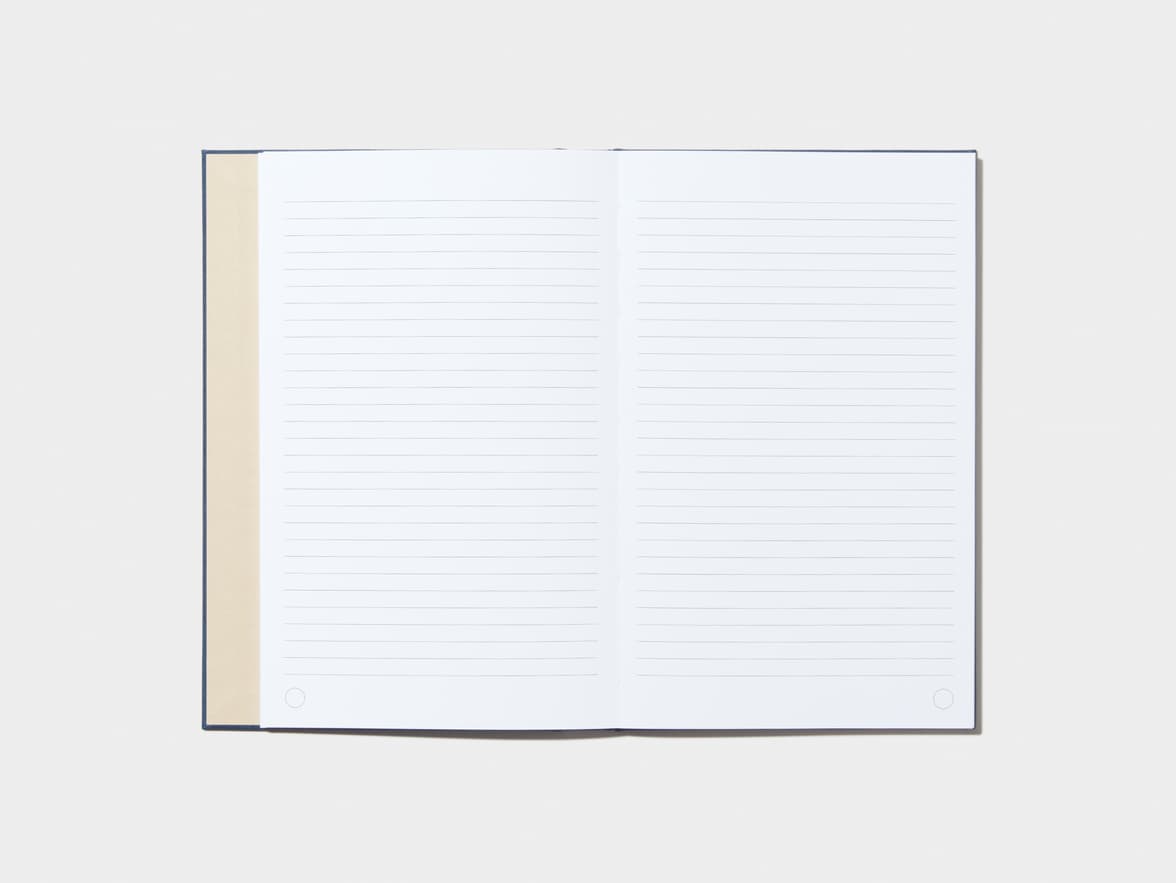 An opened Midnight Blue Hardcover Notebook with lined pages 