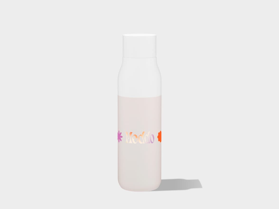 A matte, translucent bottle with a white cap, featuring a white upper body that transitions to a pale, milky pink or beige lower body containing liquid of the same color. The word "Moddo" is printed on the front in a gradient of orange to purple letters, flanked by small, stylized flower shapes in purple and orange. The bottle stands on a light gray surface, casting a soft shadow to its right.