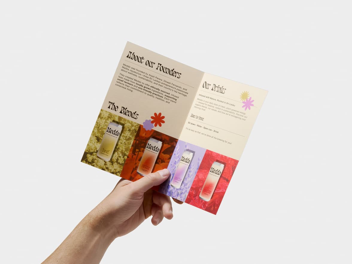 A hand holds an open brochure for Meddo Infused Natural Tea, displaying product details and colorful cans.