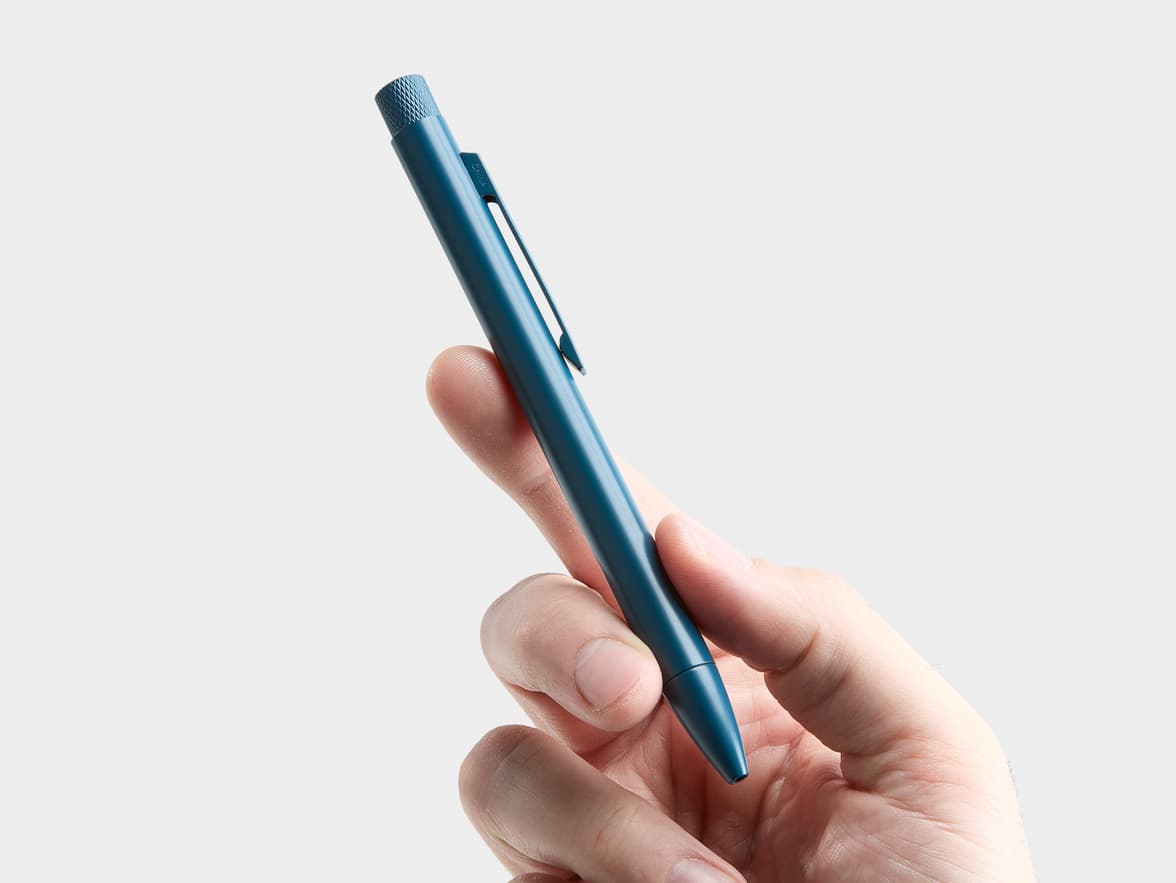 A teal pen with 'CHINA' on its clip is held by a hand.