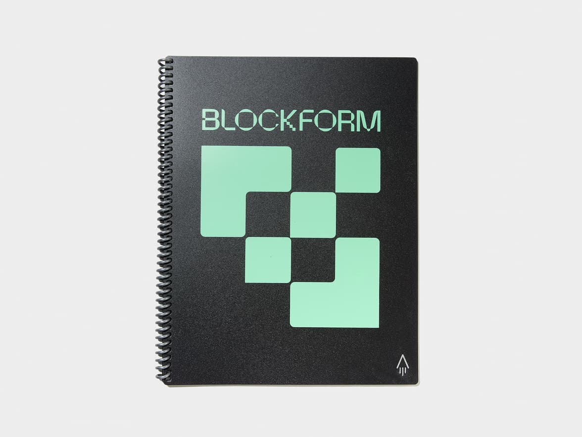 A black spiral-bound notebook with "BLOCKFORM" text and geometric light green block designs on the cover.