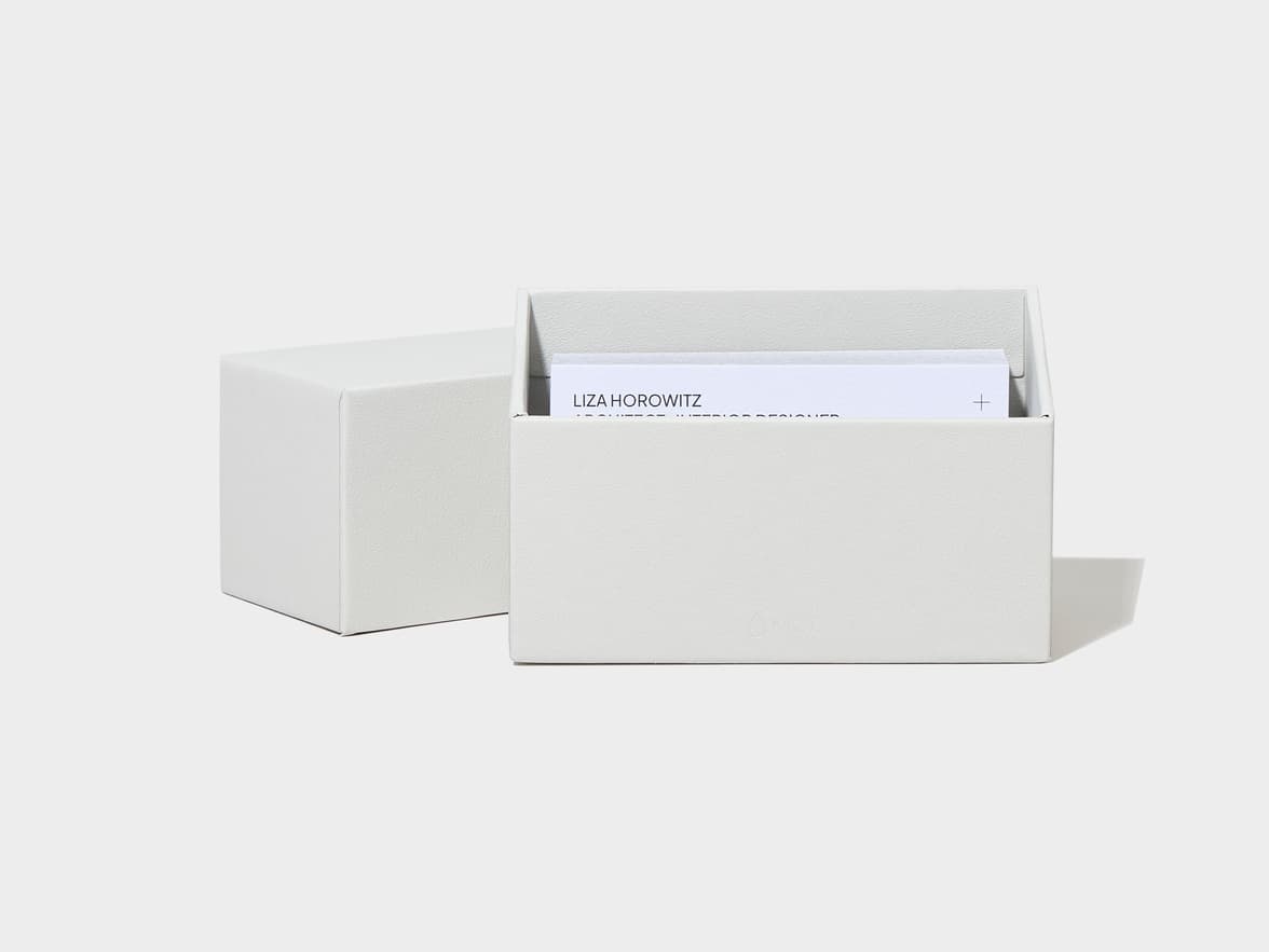 An open light grey business card holder displaying a card with "LIZA HOROWITZ", and a closed matching box beside it.