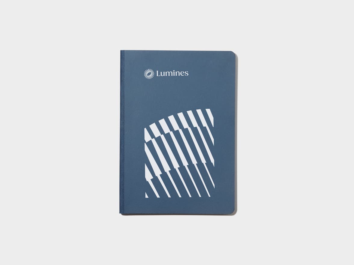 A midnight blue softcover notebook with white foil customisation.