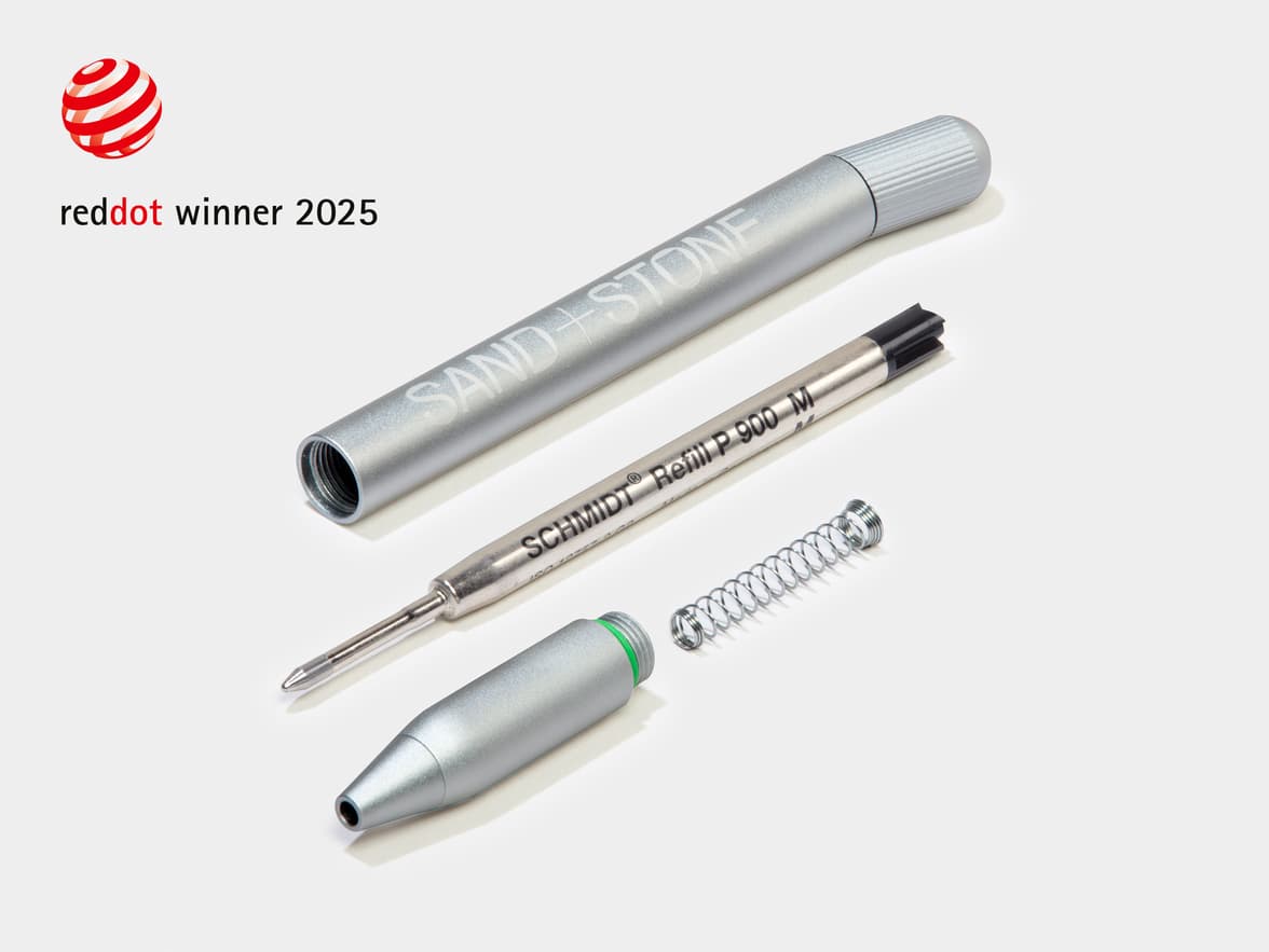A dismantled aluminium MOO Twist Pen with a red dot design award logo in the top left corner.