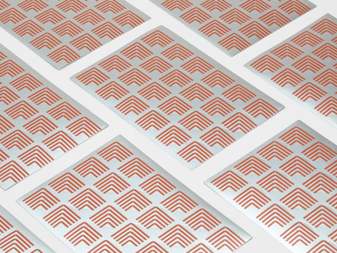 A collection of round silver stickers with orange customization.